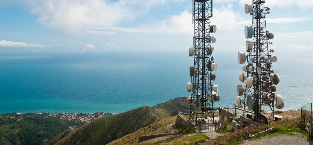 panorama with two telecommunications towers against sea and sky